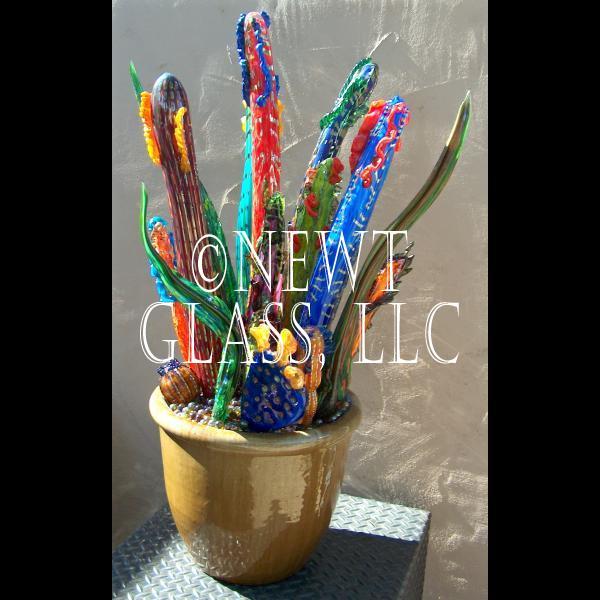 Large multi colored in gold pot
 
	Large to small cactus pieces
	installed on a framework in a gold
	ceramic pot

