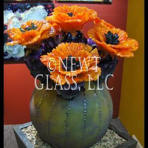 Orange cactus flowers
 
	Large arrangement with five cactus flowers in a custom made metal pot with native Arizona stone filler.&nbsp;
